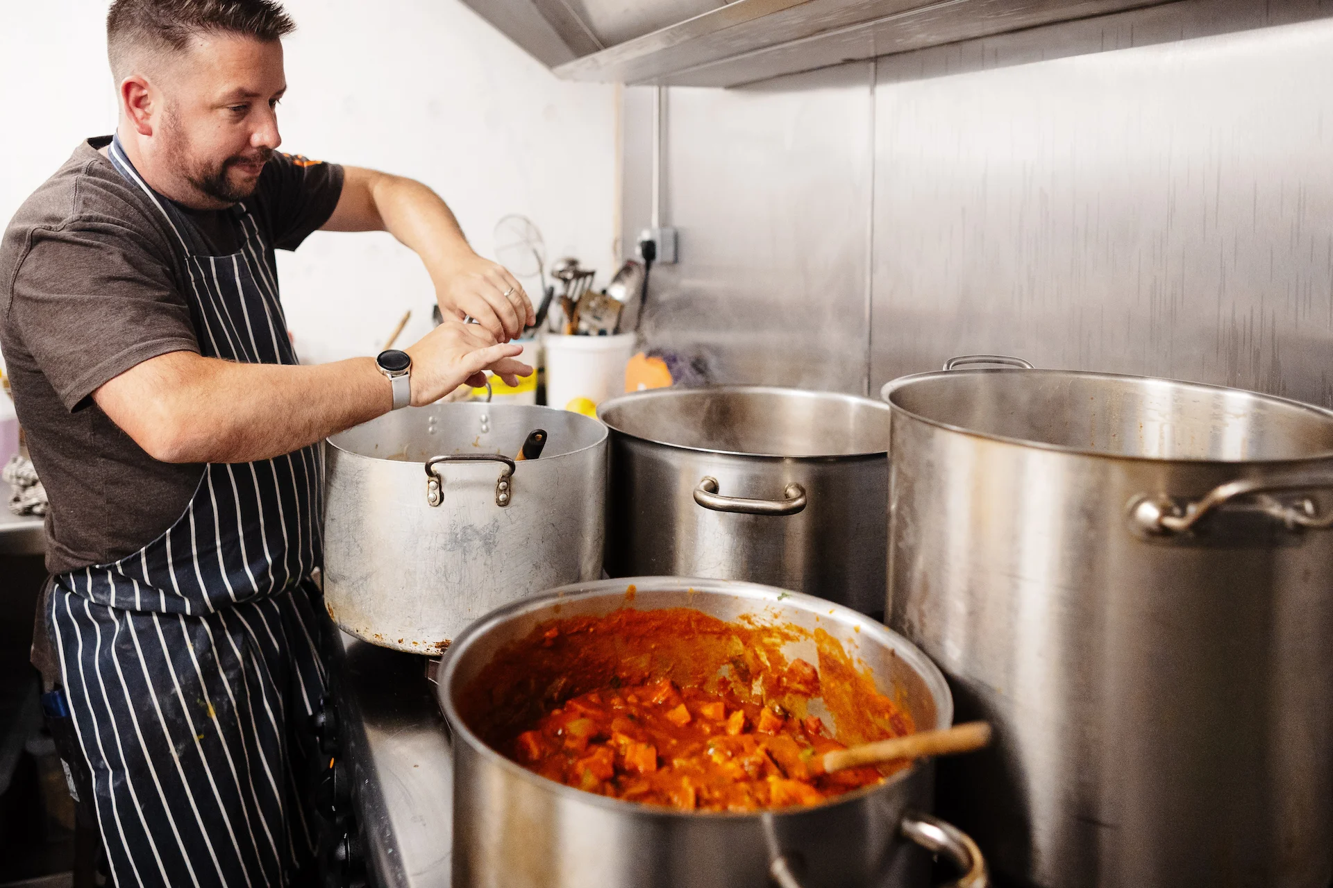 Simon Putting Ingredients into a saucepan on the cooker